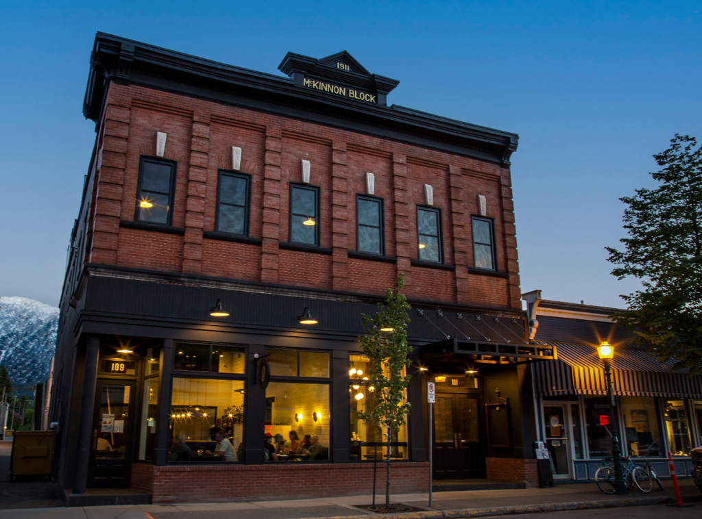 The historical McKinnong building in Revelstoke is seen on a winter night with the lights from the r